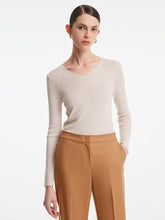 A lady wears a woolen V-neck sweater.